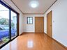 洋室：1階5畳洋室、大きな窓から光が差し込む明るいお部屋。木の温もりを感じる快適なプライベート空間です。