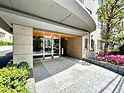 重厚感のあるマンションエントランスです。緑豊かな植栽が施されています。
