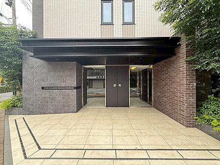 重厚感のあるマンションエントランスです。緑豊かな植栽が施されています。