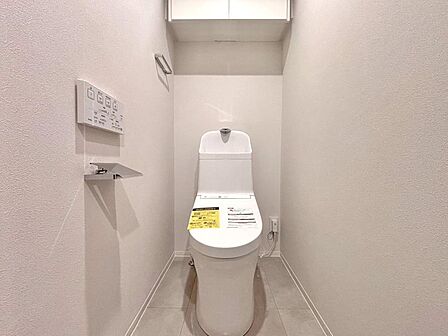 温水洗浄便座が備わっており、毎日快適にご使用いただけます。掃除用具の収納に便利な吊り戸棚付きです。