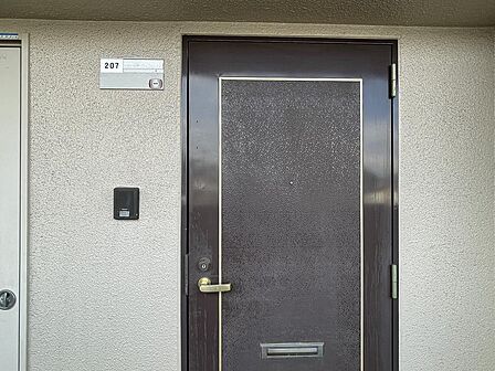 207号室の玄関。しっかりとしたドアと頑丈な鍵で、防犯面にも配慮された安心のプライベート空間へ。