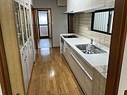 キッチンは約6.7帖あります。奥に見えているドアは浴室のドアです。洗面所とつながっているため、家事がはかどります
