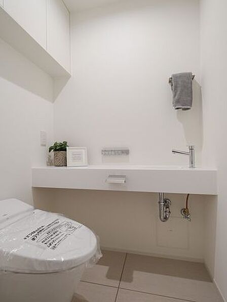 タンクレストイレやスティックリモコンでスタイリッシュな雰囲気を演出したレストルームです。タンクのお掃除が不要で家事が楽になります。また、収納棚や手洗い水栓があり便利で機能性も高い空間です。
