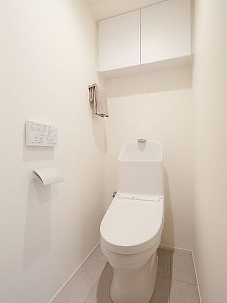 シンプルなデザインの中に安らぎが感じられるレストルームです。吊戸棚にはトイレットペーパーや掃除用具を収納でき、生活感を抑えたすっきりとした空間を実現します。