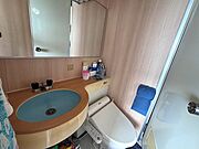 【洗面室】大鏡を設えた洗面化粧台。トイレが設置されております。