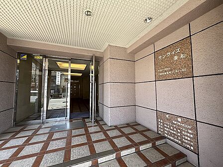 通りに面した明るいエントランス。開放感のあるガラス扉が、住まいの第一印象を爽やかに演出。