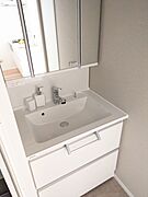 白を基調とした清潔感のあるパウダールームです。鏡裏には歯ブラシや化粧品も収納できます。 