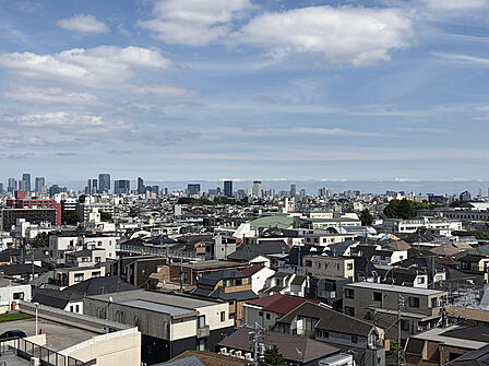 9階部分からの素晴らしいパノラマ眺望。どこまでも広がる青空と、都心部の街並みを一望できる開放的なロケーションです