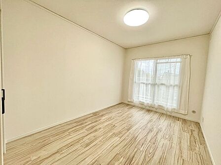 大きな窓から陽光が降り注ぐ明るい洋室