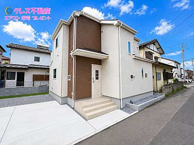 外観：落ち着いた外観デザインのA号棟。駐車スペースも確認しやすい現地写真です。