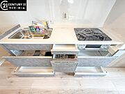 【キッチン】　効率的にお料理できる便利な3口コンロをはじめとしフライパンなど大きな料理道具をきれいに収納できる機能的な大型収納スペースが備わった快適なキッチンスペース