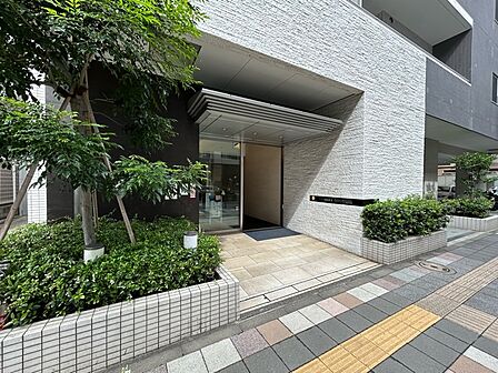 植栽を配した落ち着きあるエントランス。道路から一歩奥まったアプローチが設けられています。