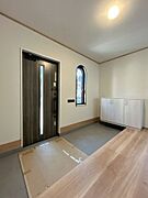 【リフォーム中】玄関ホール。床フローリング重ね張り、照明器具交換、天井・壁クロス張替でよりいっそう明るくなった玄関。家族の歴史を温かく見守ります。