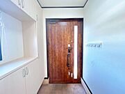 【現況販売】玄関内部写真を撮影しました。木目調のおしゃれな玄関ドアで採光ガラスもついているので、玄関が明るくなっています。