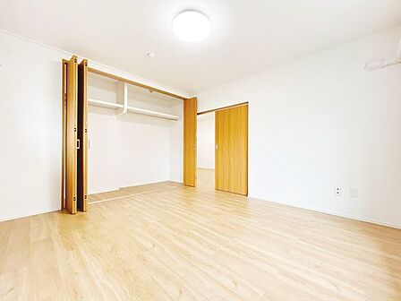 【洋室8帖別角度】令和5年に床材張替、クロス張替、建具交換を実施しております。クローゼット内には枕棚とハンガーパイプが設置されており、衣類等の収納に便利です。