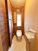 【トイレ】1階のトイレです。木目調の壁紙がおしゃれで、落ち着いた清潔感のあるトイレとなっています。ウォシュレット付きで手洗い別のトイレなので、嬉しいですね。