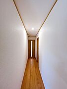 【リフォーム済】廊下の写真です。クロス張替、フロア上張、照明器具設置を行いました。各居室に繋がる導線となっております。