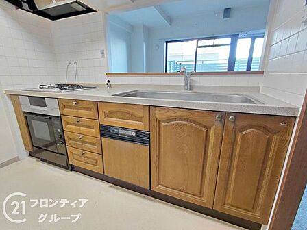 木目調のパネルが上品な印象を与えるシステムキッチンは毎日の料理を楽しく演出します　広い作業スペースと充実した収納を備えており機能性と美しさを兼ね備えた洗練された空間です