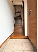 玄関を入って右側がリビング。正面は2階へ続く階段です。