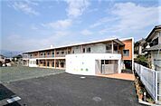 【愛歩保育園】609ｍ　2010年4月に開設された新しい2階建ての園舎は、広い園庭を見渡すように建っています。園児さんが元気よく園庭を駈け回っています。