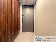 ブーツや大型の履物も収納できるトール型のシューズボックス。玄関框は床タイルと同一タイル張りで上質な雰囲気を演出。※AIにて画像処理をしたものであり、現況と異なる場合がございます。