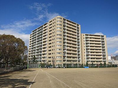 外観：南西側隣地グラウンドより見た現地マンション全景