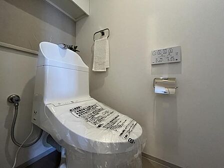 ~トイレ~ 上部に吊戸棚が設置されている温水洗浄機能付トイレです。