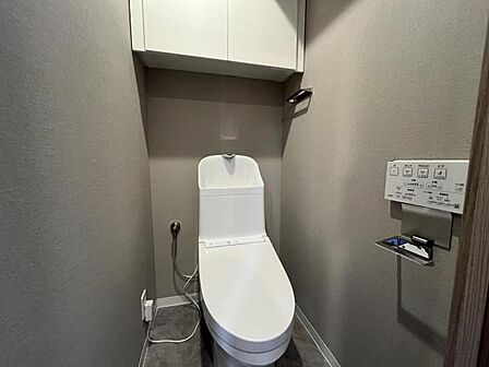 ~トイレ~ 上部に吊戸棚が設置された温水洗浄機能付のトイレです。