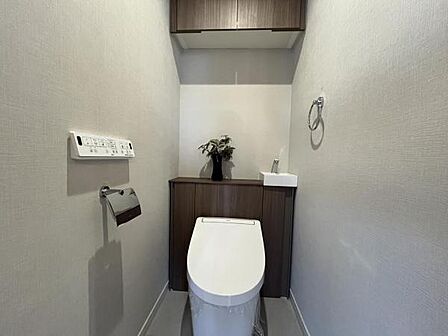 ~トイレ~ 上部に吊戸棚が設置された温水洗浄機能付トイレです。