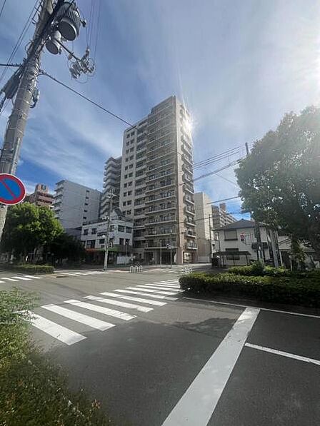 物件北東側前面道路北側からのマンション全景です。平坦地立地ですので、移動もラクラク。