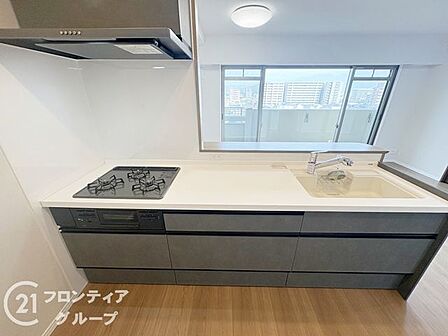窓からの景色を眺めながら料理を楽しめる開放的なキッチンです。高級感漂うダークトーンのパネルと清潔感のある天板が美しく、毎日の家事時間を特別なひとときへと変えてくれる洗練された空間になっています