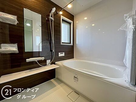 落ち着いた木目調のアクセントパネルが癒やしの空間を演出するバスルーム。一日の疲れを優しく解き放つゆったりとした浴槽に身を委ね、プライベートなリラックスタイムを心ゆくまでお過ごしいただけます