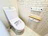 トイレ：清潔感あふれるトイレ空間。壁のタイル柄がアクセントとなり、快適なひとときを演出します。温水洗浄機能も備え、日々を心地よく過ごせます。