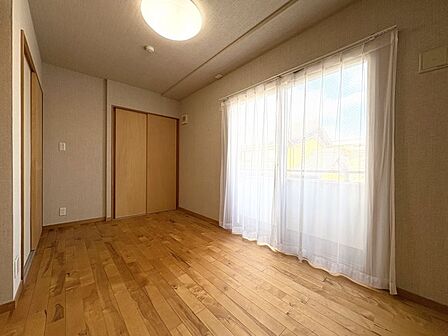 木目のフローリングが暖かみのある室内に。明るい寝室で心地のいい朝を迎えられそう。