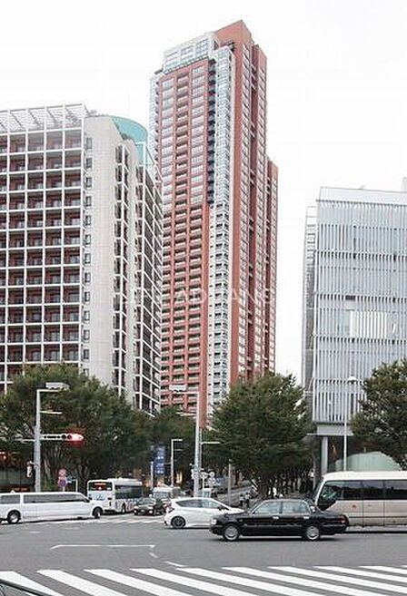 ブラウンを基調とした落ち着きのあるデザインが特徴的な高層タワーマンションで、前面には整備された道路や街路樹が広がっており、周辺には多様な建築物が立ち並ぶ都市的な景観となっております。