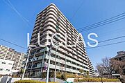 空の青と建物のコントラストが印象的な、存在感のあるマンションです。周囲の落ち着いた雰囲気も魅力で、日々の暮らしに安らぎを与えます。