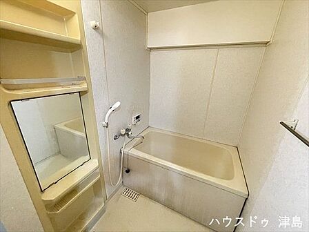柔らかいナチュラルな印象の浴室。ミラー付き収納が取り付けられ、シャンプーやボディソープなど床置きせずに片付けられます。