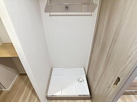 上部にパイプハンガーやコンセントを備えた、すっきり機能的な洗濯機置き場です。