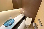 トイレ。温水洗浄便座つきなので清潔を保てます。手洗い場つきで、タンクレストイレです。すっきりとした見た目になっています。上品な色味のアクセントクロスが素敵です。