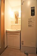 玄関とキッチンの間に洗面化粧台・電気温水器があります。