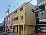 外観：鮮やかな外観が目を引く3階建ての建物です。駐車スペースも確保されており、都市での生活をサポートします。