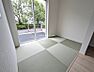 リビング/ダイニング：緑豊かな景色を望む窓辺の和室空間。市松模様の畳がモダンな印象を演出し、落ち着いたひとときをお過ごしいただけます。