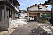 建物横にコンクリート舗装の駐車スペースを確保。玄関まわりの動線も確認できます。