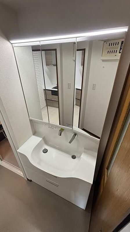 三面鏡収納付き水の垂れにくい洗面ボウルのある洗面化粧台。上から使うものが取り出しやすい引き出し収納。