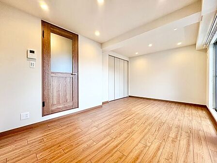 ナチュラルな木目調の床から木のぬくもりを感じられる広々としたリビングルーム。