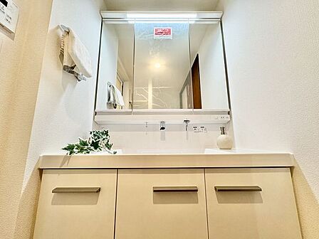 壁一面の鏡で朝の身だしなみもくまなくチェック。清潔感溢れるスタイリッシュなデザインの洗面化粧台。