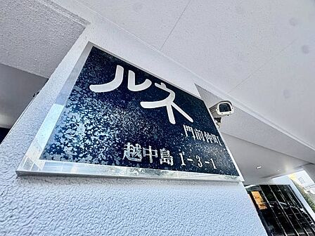存在感のあるマンション名プレートは、落ち着きのある温かな空間を演出します。家族が笑顔になれる住まいへ。