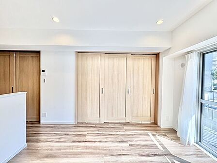 ナチュラルな木目調の床から木のぬくもりを感じられる広々としたリビングルーム。