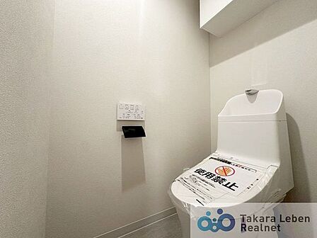 ウォシュレット機能付きのトイレは壁掛けリモコンの上位グレードを採用。便座がスッキリした印象となり、限られた空間を広く見せる効果があります。
