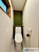 1階のお手洗い。ウォシュレット機能付きのトイレは壁掛けリモコンの上位グレードを採用。便座がスッキリした印象となり、限られた空間を広く見せる効果があります。